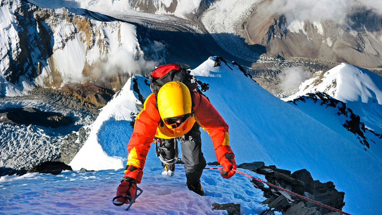 An overhead view of a belayed Everest climber, with a long drop below