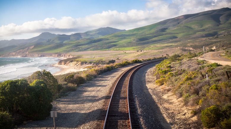 Train tracks between mountain and ocean