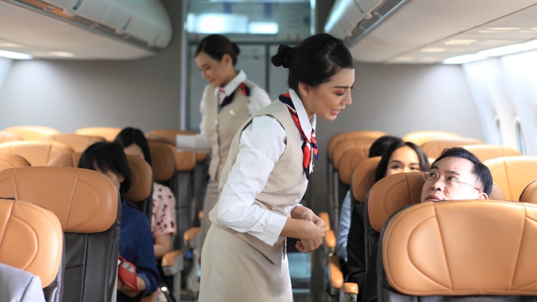 flight attendant talking to passenger