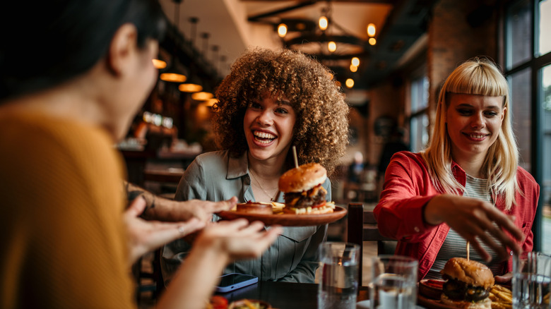 Young happy people having lunch together