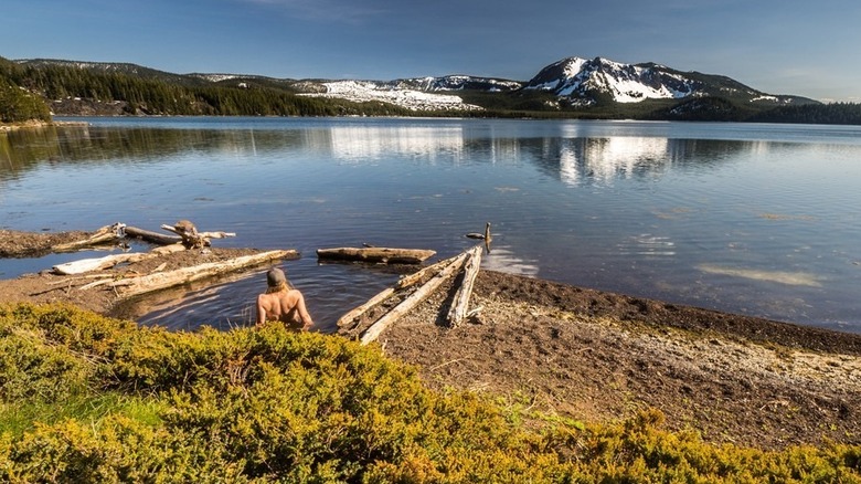 Several hot spring pools are dug from sand along the shore of scenic Paulina Lake