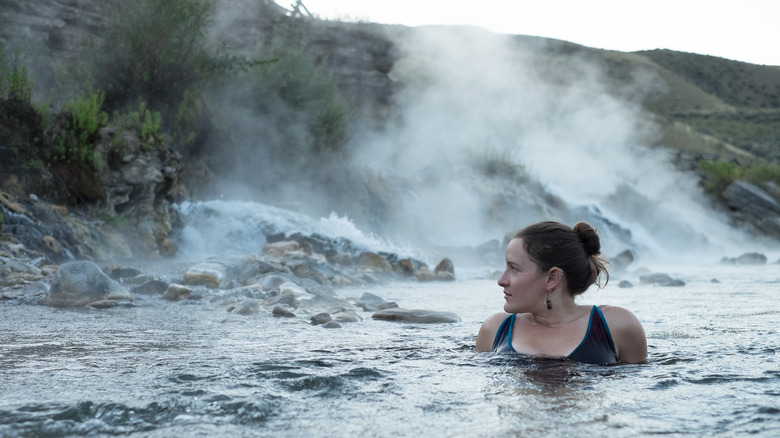 A woman soaks in an outdoor hot spring