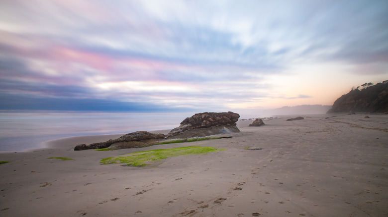 A colorful sunset at low tide on Ona Beach in Oregon.