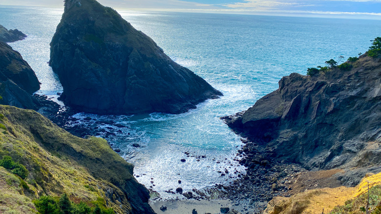 Dramatic rock formations surround a hidden beach cove at Port Orford Heads State park in southern Oregon
