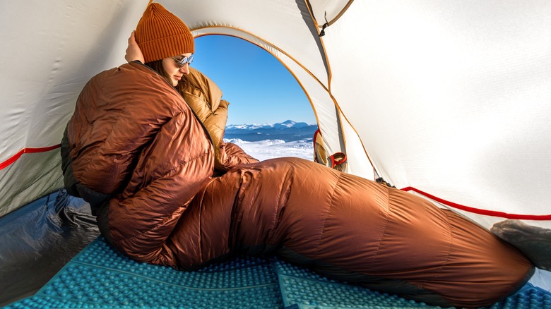 woman cooking outside tent in snow