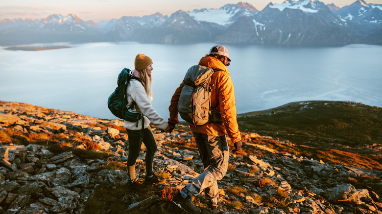 A couple hiking with lake and mountains in background