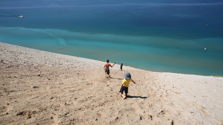 People run down the steep dune at Sleeping Bear Dunes