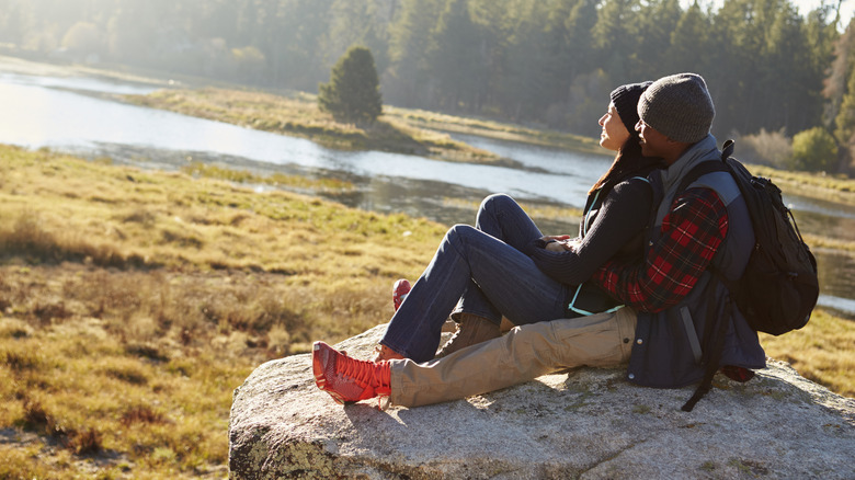 couple on rock overlooking lake