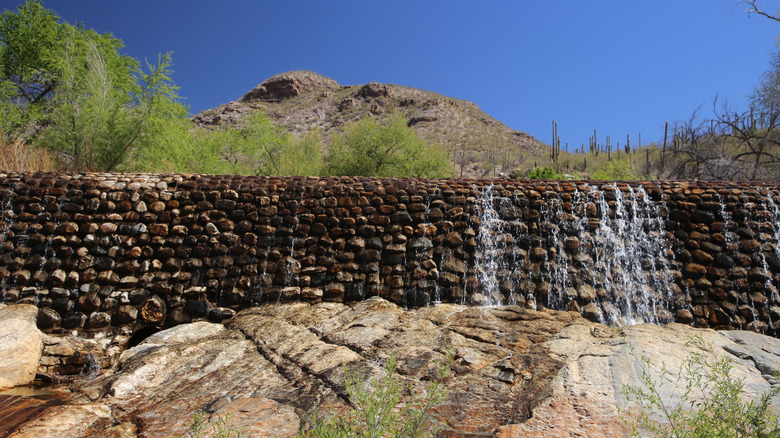 waterfall on a dam with mountain