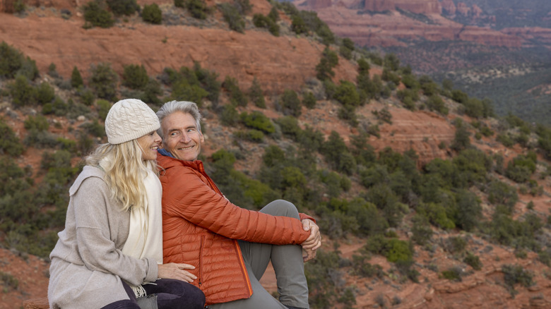 A couple on a red-rock mountain enjoying the view in the winter.