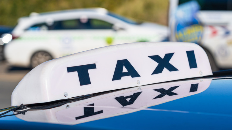 A white taxi sign on top of a car