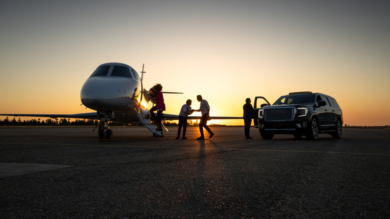 Passengers getting a private car to a private jet