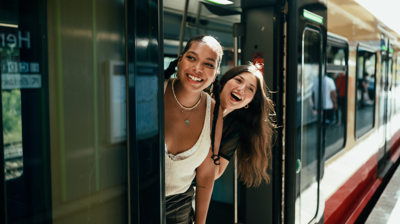 Young travelers looking out train