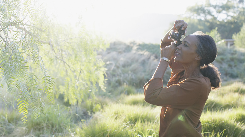 woman taking pictures in park