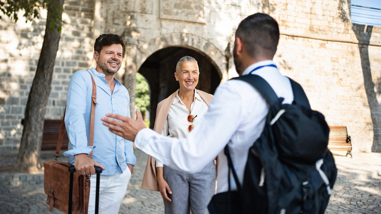 Tourists smiling and speaking to local