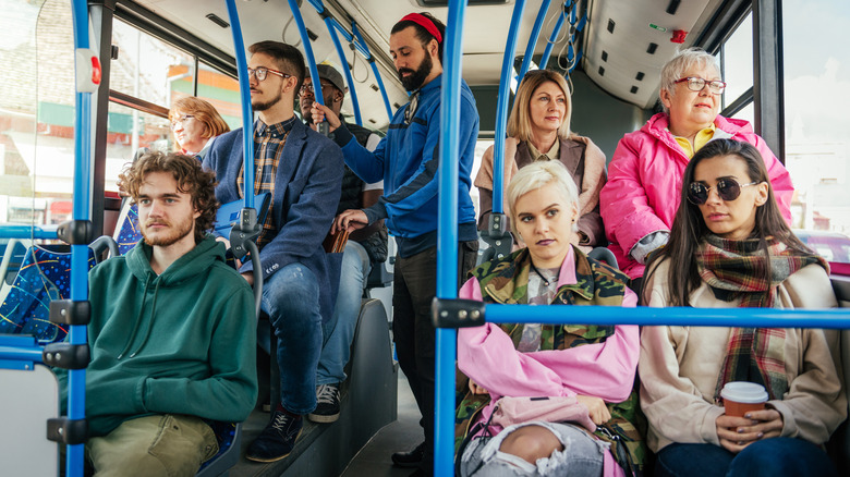 Man being pickpocketed on public transport