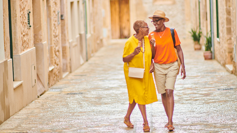 Two women walking on a street smiling