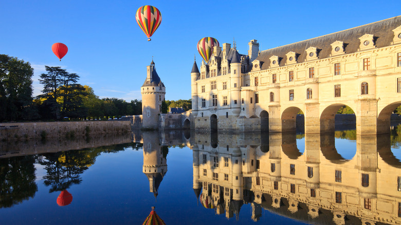 hot air balloons glide over the château de Chenonceau over the River Cher