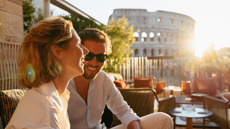 Two diners occupy a table near the Colosseum at sunset