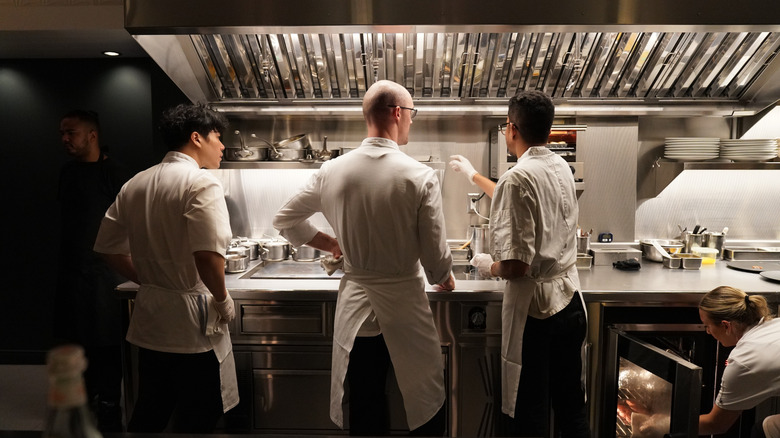 cooks in front of a Michelin star rated kitchen in NY