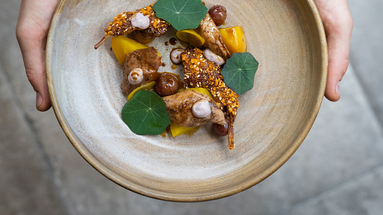 Overhead shot of a fine dining dish carried by chef