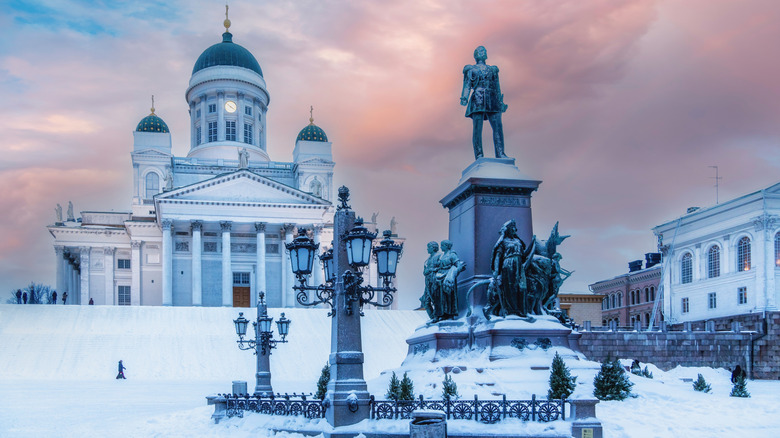 a snow covered cathedral with a statue out front