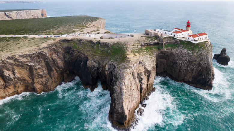 lighthouse on high cliffs and strong waves hitting the rock at Cape St. Vincent