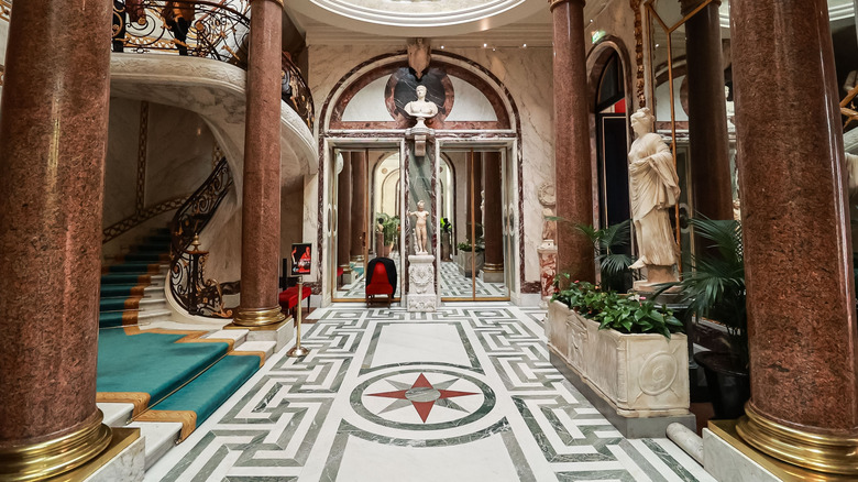 An opulent foyer room with staircase and marble columns inside the Musée Jacquemart-André
