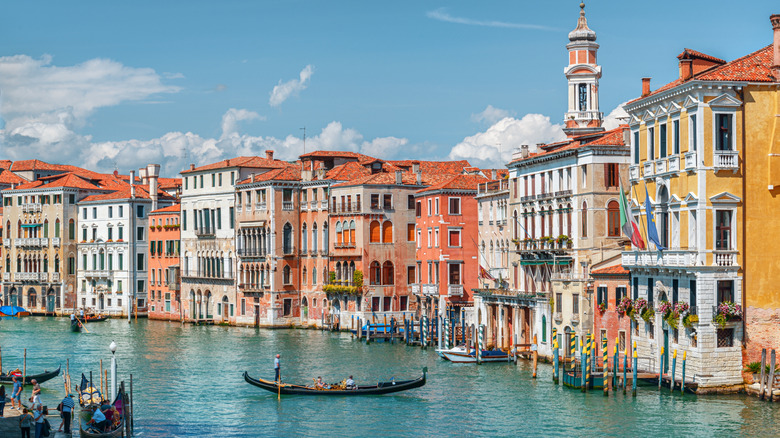 View of the Grand Canal with boats and colorful facades of old medieval houses from the Rialto Bridge in Venice, Italy