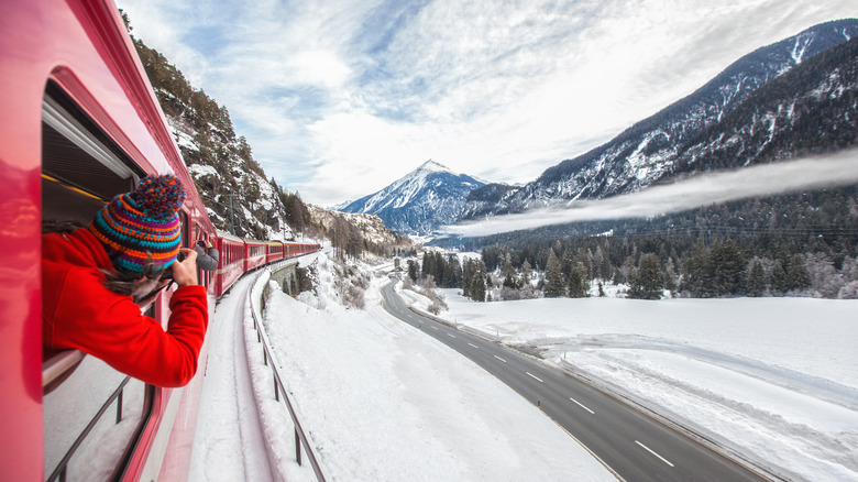red train in snowy mountains
