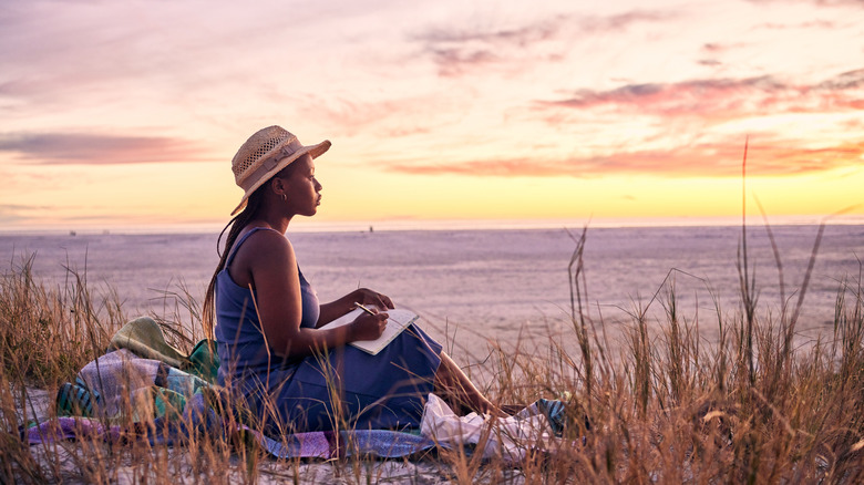 Woman journaling on beach