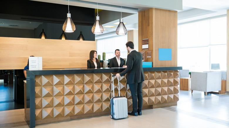 A businessman making a booking at a hotel front desk.