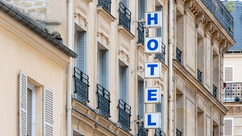 Sign with the word 'HOTEL' written in bright capital letters on the facade of a building in Paris, France.