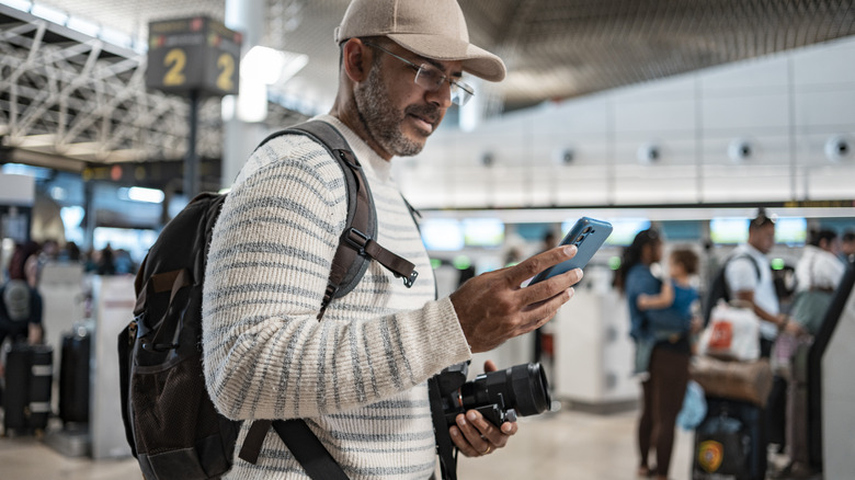 Airport traveler looking at phone