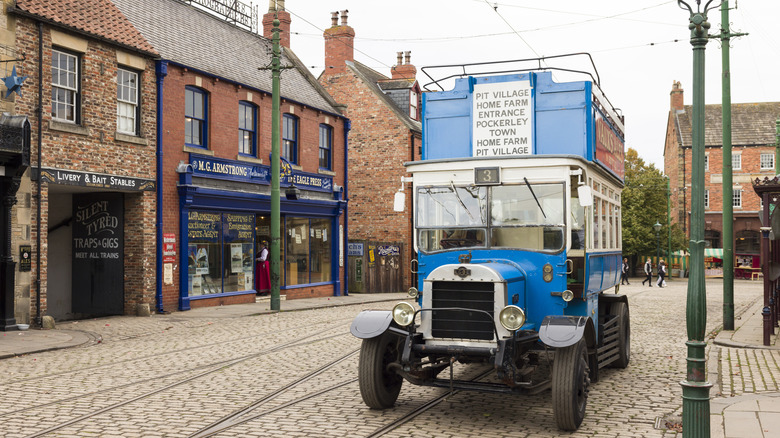 old blue bus on cobbled street