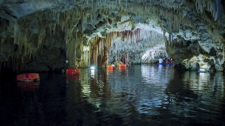 a boat explores the underground river in Diros Caves