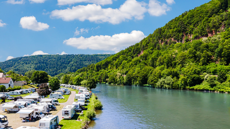 Aerial view of an RV camping site on a river with hills surrounding