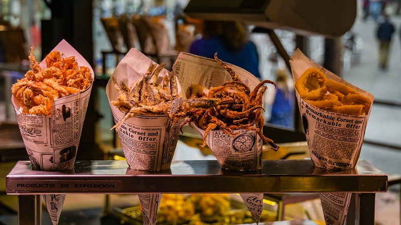 Cones made of newspaper holding various fried fish