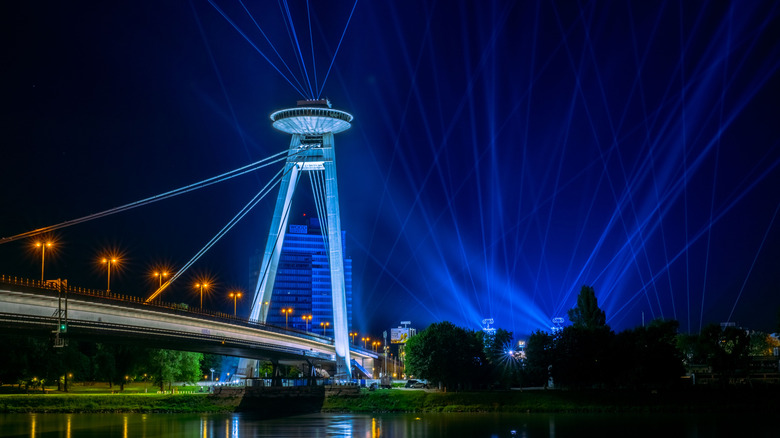 Night view of the UFO Bridge in Bratislava, Slovakia, illuminated with blue lights