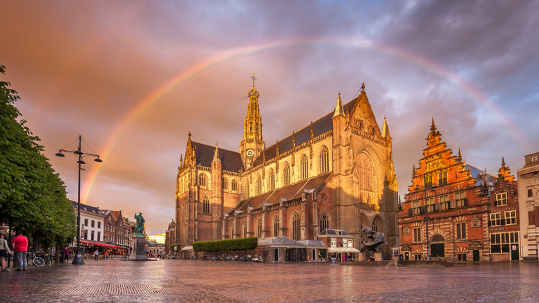 A photo of a large church with a rainbow above it in Haarlem, Netherlands