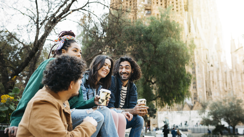 Group of friends on a bench chatting by La Sagrada Familia