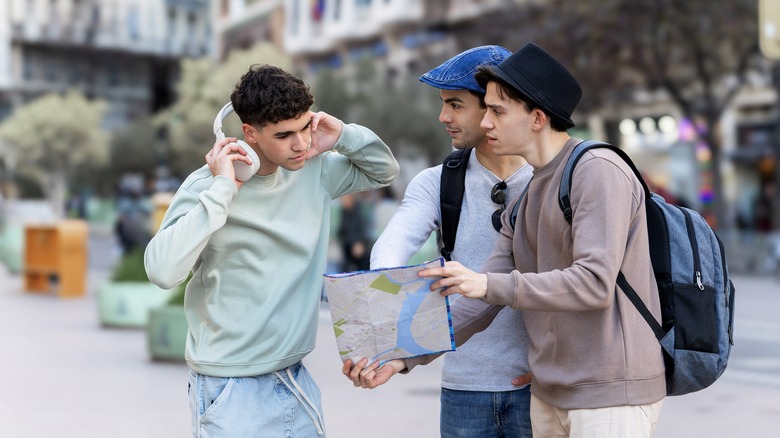 Two male tourists holding a map asking for directions