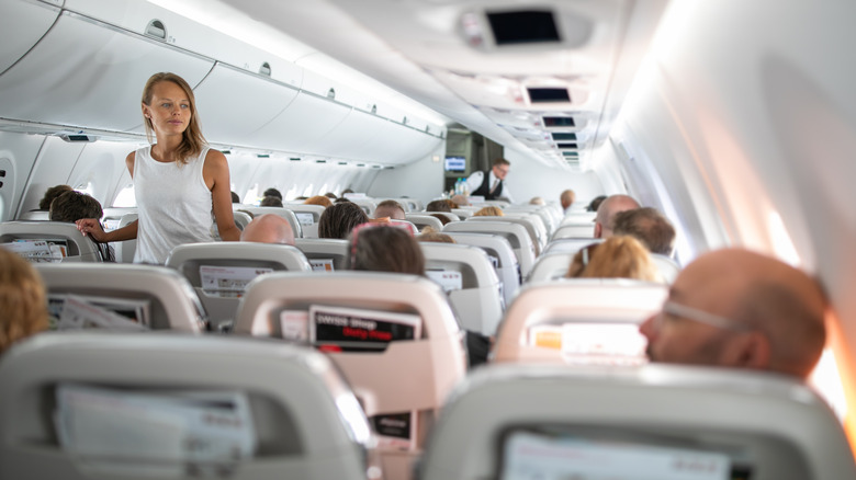 woman walking in plane aisle