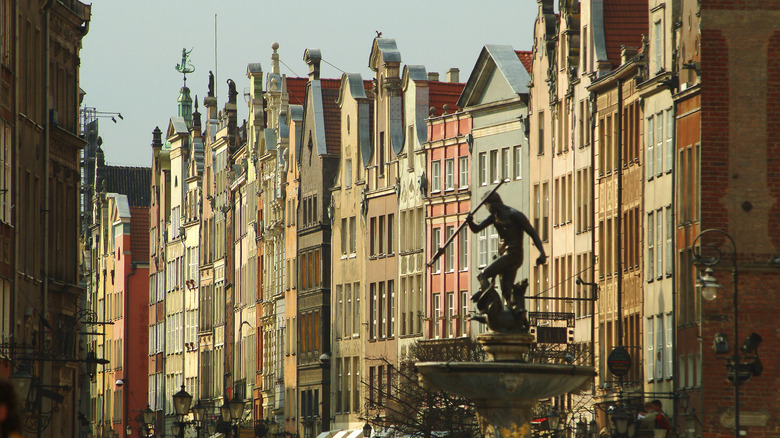 Neptunes fountain with colorful buildings behind it