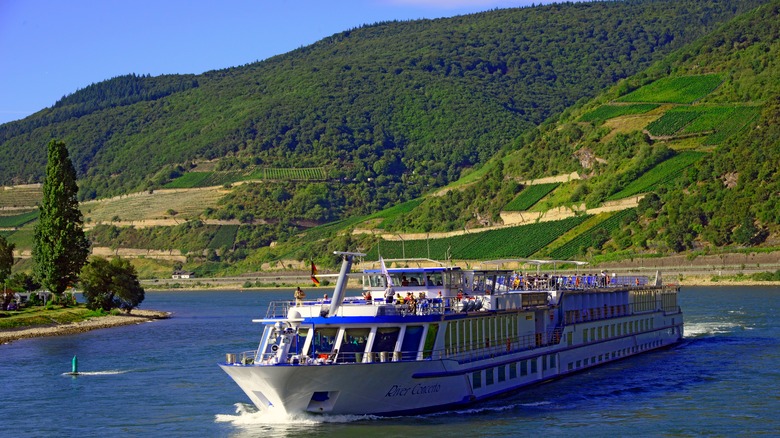 A riverboat gliding in the water among green hills in Germany