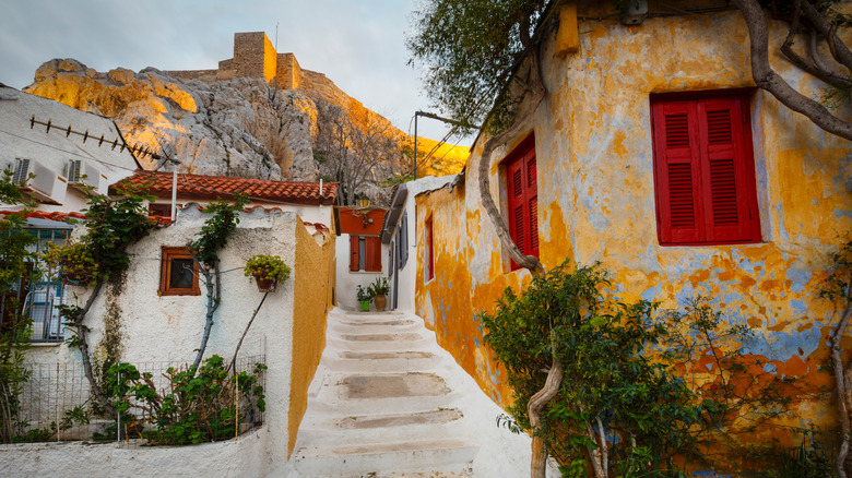 Narrow street in Anafiotika with stone houses and the Acropolis in the background