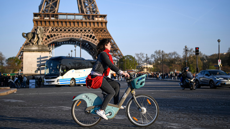 woman on a bike passing in front of the Eiffel Tower