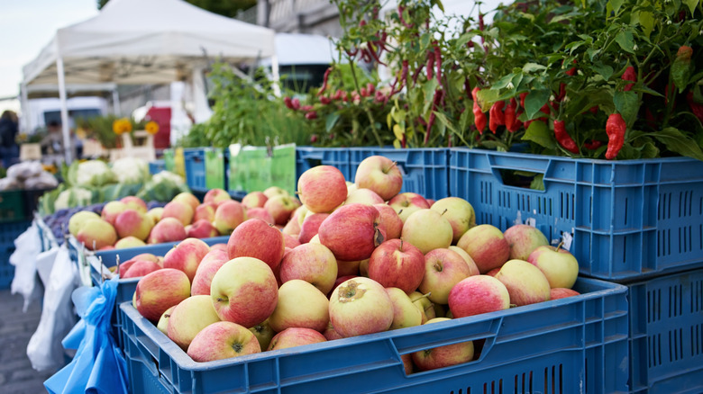 Crates of apples and peppers at an outdoor market