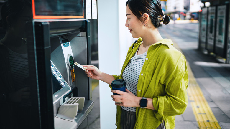 Traveler inserting card into ATM