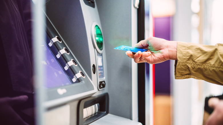 Hand inserting card into ATM